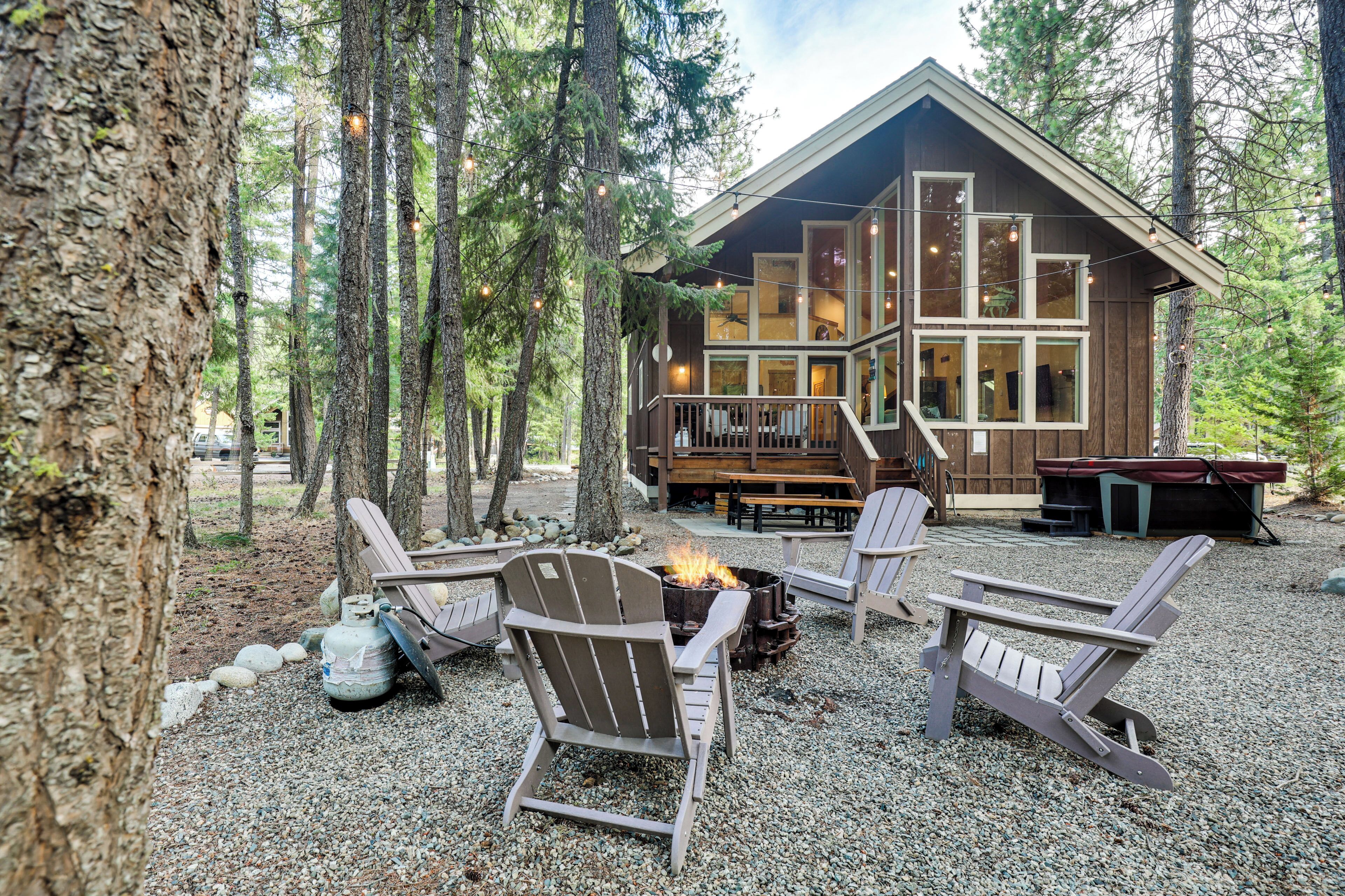 Une cabane dotée d’une terrasse, d’un espace salon extérieur et d’un foyer.