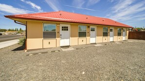 A building with a red roof, beige walls, and multiple doors. - Private Patio, Steps to Lake: Soap Lake Studio! (Soap Lake)