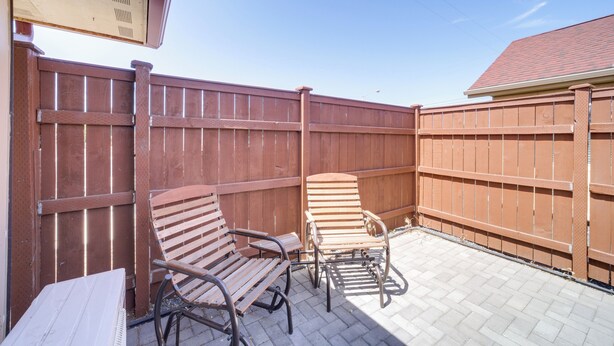 A patio area with two wooden chairs and a table, enclosed by a wooden fence. - Private Patio, Steps to Lake: Soap Lake Studio! (Soap Lake)