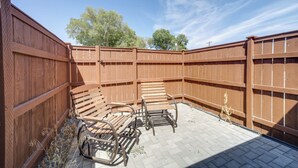 A patio area with wooden benches and a brick floor, enclosed by a wooden fence. - Walk to Water: Soap Lake Studio w/ Patio! (Soap Lake)