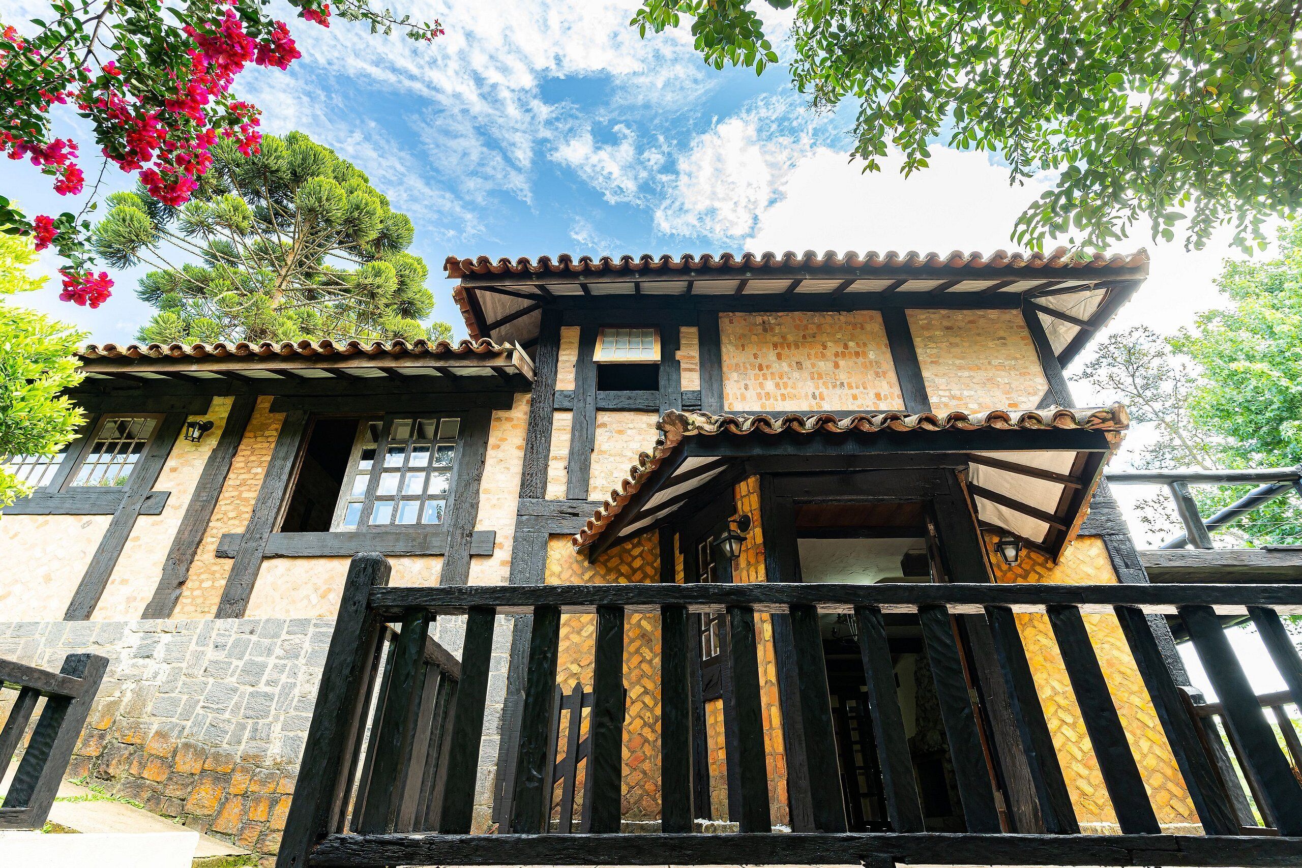 Um edifício tradicional com telhado de azulejos, vigas de madeira e uma parede de pedra.