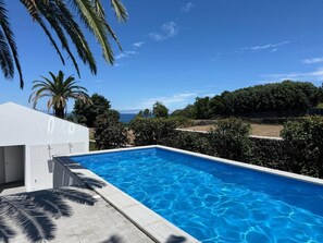 Piscine extérieure, parasols de plage, chaises longues