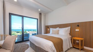 A modern hotel room with a large bed, a view of the city, and a balcony. - Ápice - by Azores Green Villas  (Ponta Delgada)