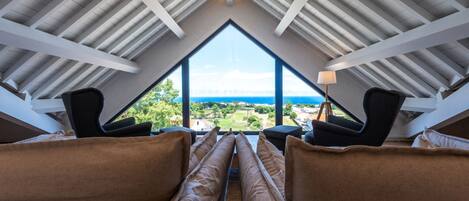 Suite superior, vista al jardín | Área de sala de estar | Smart TV de 50 pulgadas con canales por cable y libros