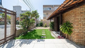 A residential property with a paved patio, a small lawn, and a brick wall. - 3BR House 230m From Beach w/ BBQ & Grg Rgv115 (Bombinhas)