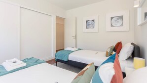 Una habitación de hotel con dos camas, un armario y dos cuadros enmarcados de la luna en la pared.