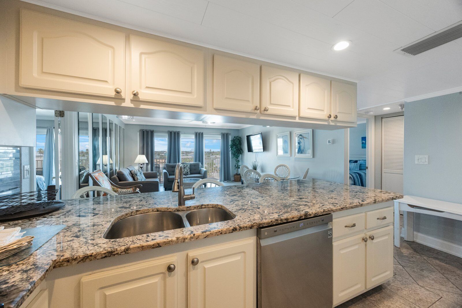 A modern kitchen with granite countertops, stainless steel appliances, and light-colored cabinetry.