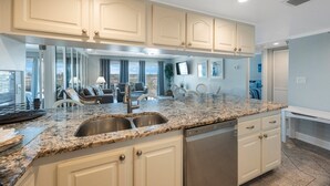 Una cocina moderna con encimeras de granito, electrodomésticos de acero inoxidable y armarios de tonos claros.