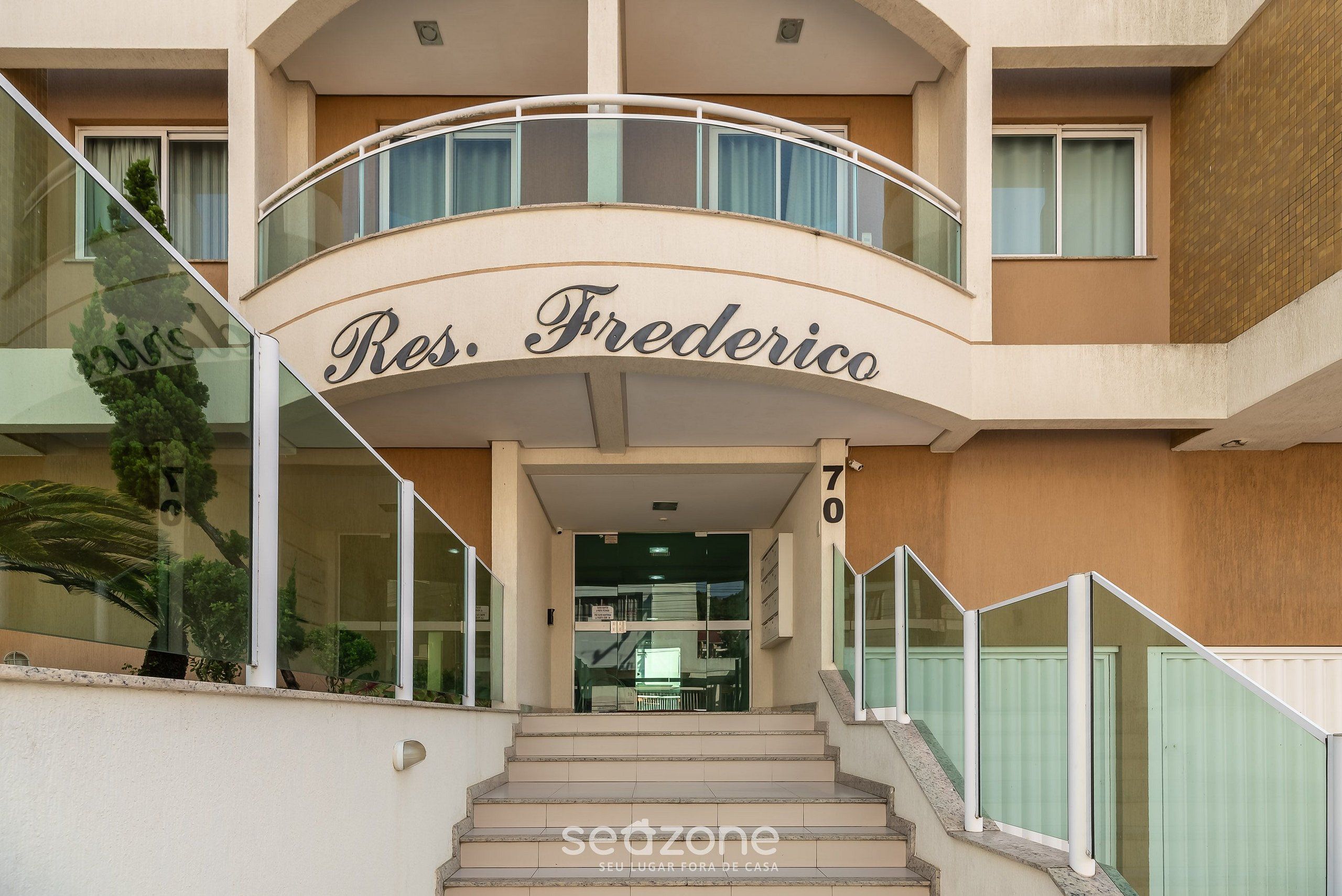 A hotel entrance with a curved balcony and the name "Res. Frederico" above the doors.
