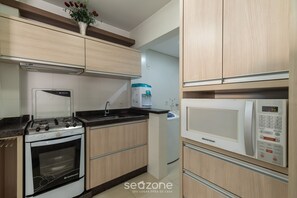 Egy modern konyha gázfőzőlappal, mikrohullámú sütővel és beépített sütővel.