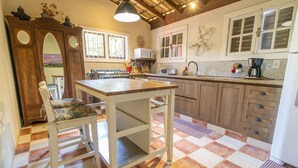 A kitchen with a wooden table, a stove, and a sink. - Comfortable Duplex in Praia do Rosa - SC Rfe000 (Imbituba)
