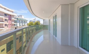 A modern apartment with a balcony, large windows, and a view of neighboring buildings. - Beaut apt in Praia do Forte, 700m From sea Rbm207 (Cabo Frio)