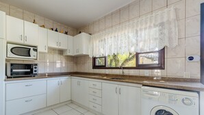 A kitchen with white cabinets, a microwave, a toaster, a sink, and a washing machine. - 3BR Home w/ BBQ 140m From the Beach Rae0126 (Bombinhas)