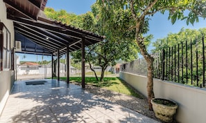 A covered outdoor area with a tiled floor, a pergola, and a tree. - 3BR Home w/ BBQ 140m From the Beach Rae0126 (Bombinhas)