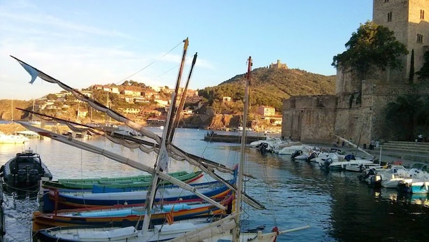 Un port amb vaixells, un castell i un assentament al turó.