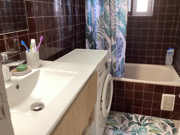 A bathroom with a sink, a toilet, and a shower area. - Large T2 1st line 180° view and parking space (canet en roussillon)