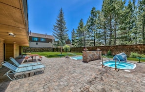 Un jardin avec une piscine, des chaises longues et un espace barbecue.