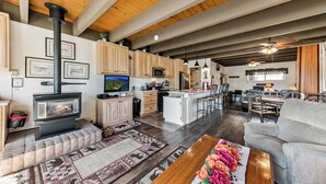 A spacious living area with a fireplace, wooden cabinets, a kitchen, and a dining area. - 439AW Tahoe Keys Studio Perfect Couples Get Away (South Lake Tahoe)