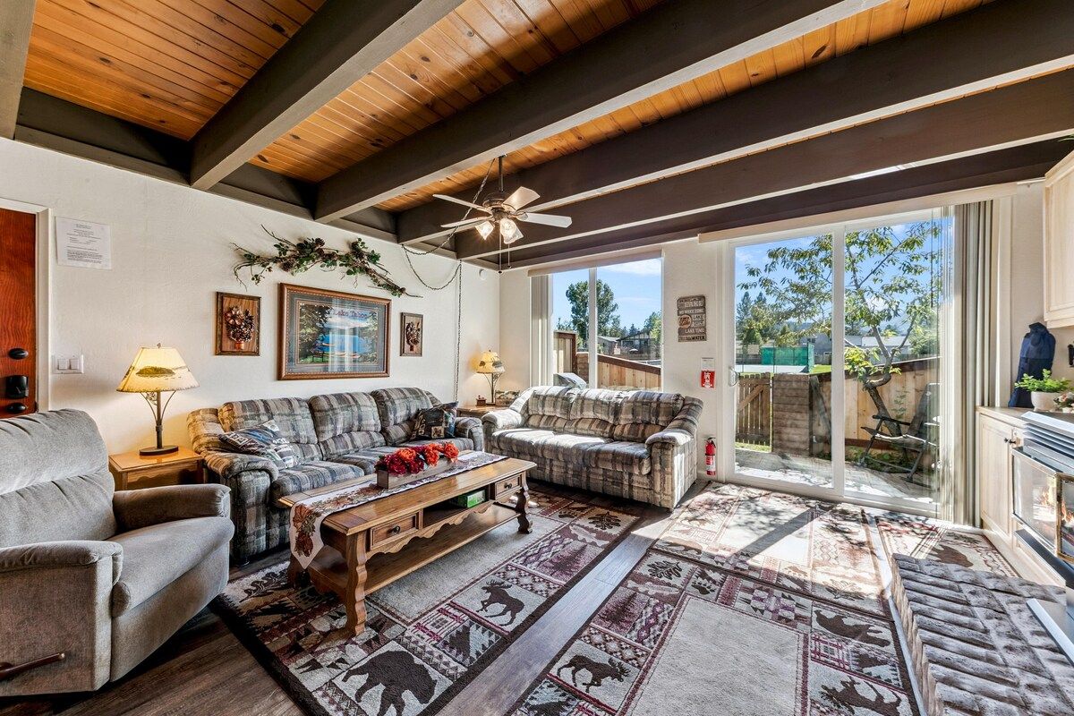A living room with a ceiling fan, two sofas, a coffee table, and a patterned rug.