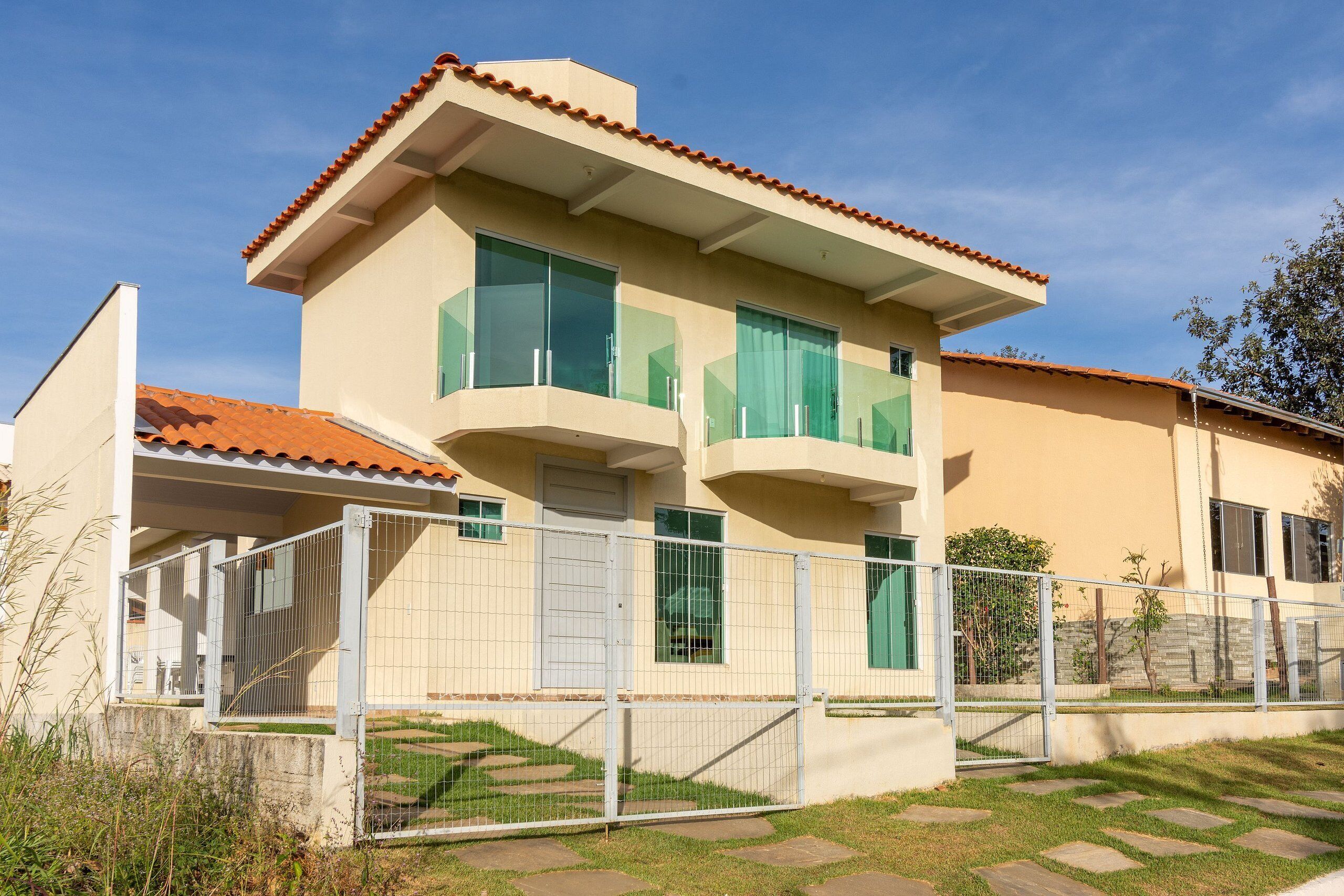 A two-story building with a flat roof, large windows, and a gated entrance.