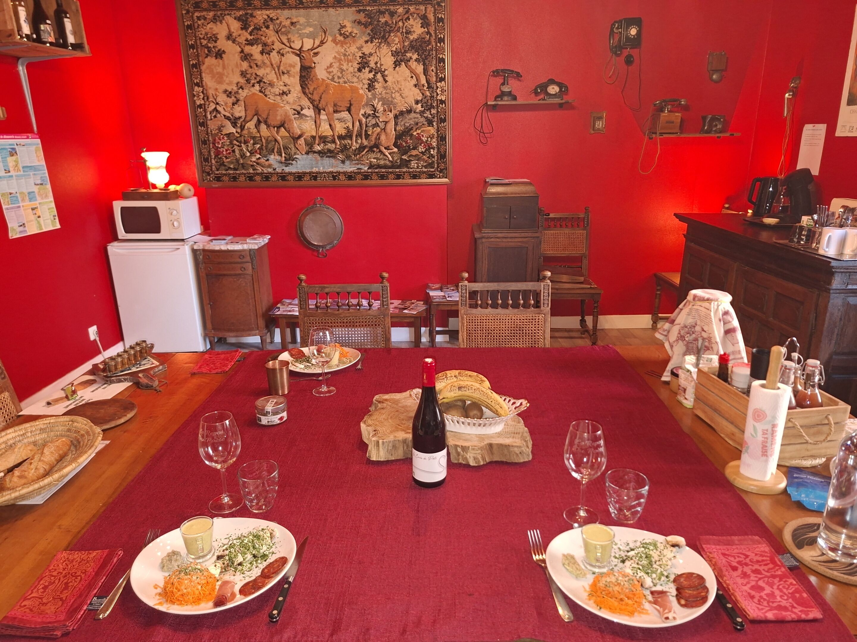 A dining area with a red carpet, wooden furniture, and a table set for a meal.