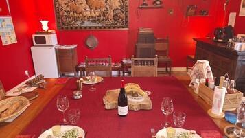A dining area with a red carpet, wooden furniture, and a table set for a meal.