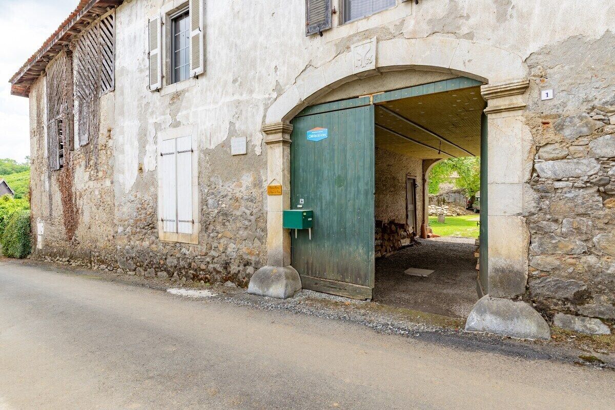 Un edificio rústico de piedra con una puerta verde y un pequeño buzón.