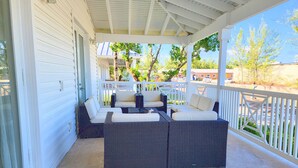 A covered patio with wicker furniture and a view of the street. - Exclusive Bimini Bay home with private boat slip. (Bimini)