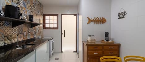A kitchen with patterned tiles, a wooden cabinet, and a fish-shaped decoration.