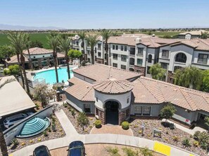 Un complejo residencial con varias edificaciones, una piscina y una vista despejada del paisaje circundante.