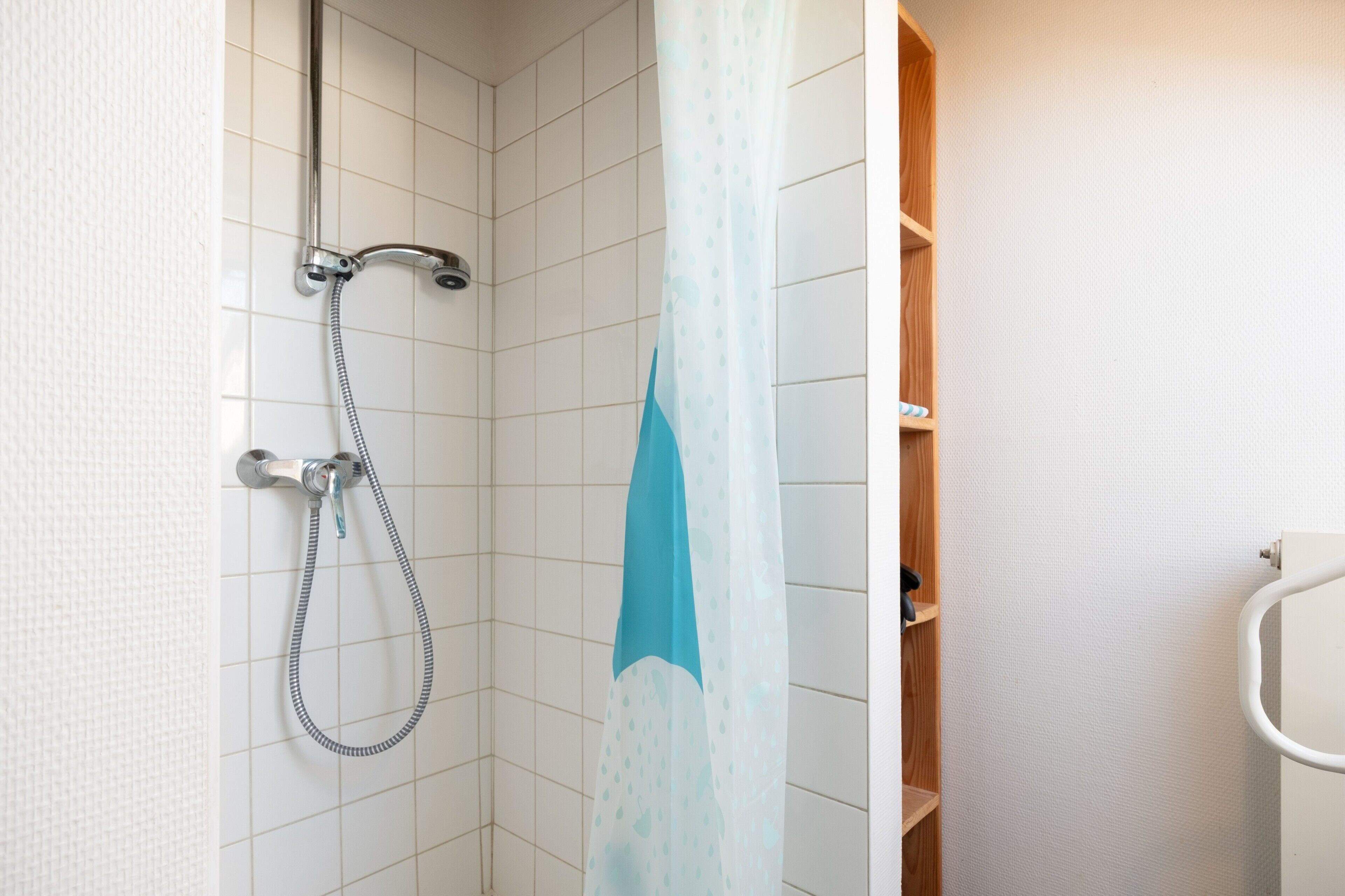 Eine Dusche mit Duschkopf und Duschvorhang.