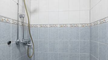 A small, tiled shower room with a showerhead and hose.