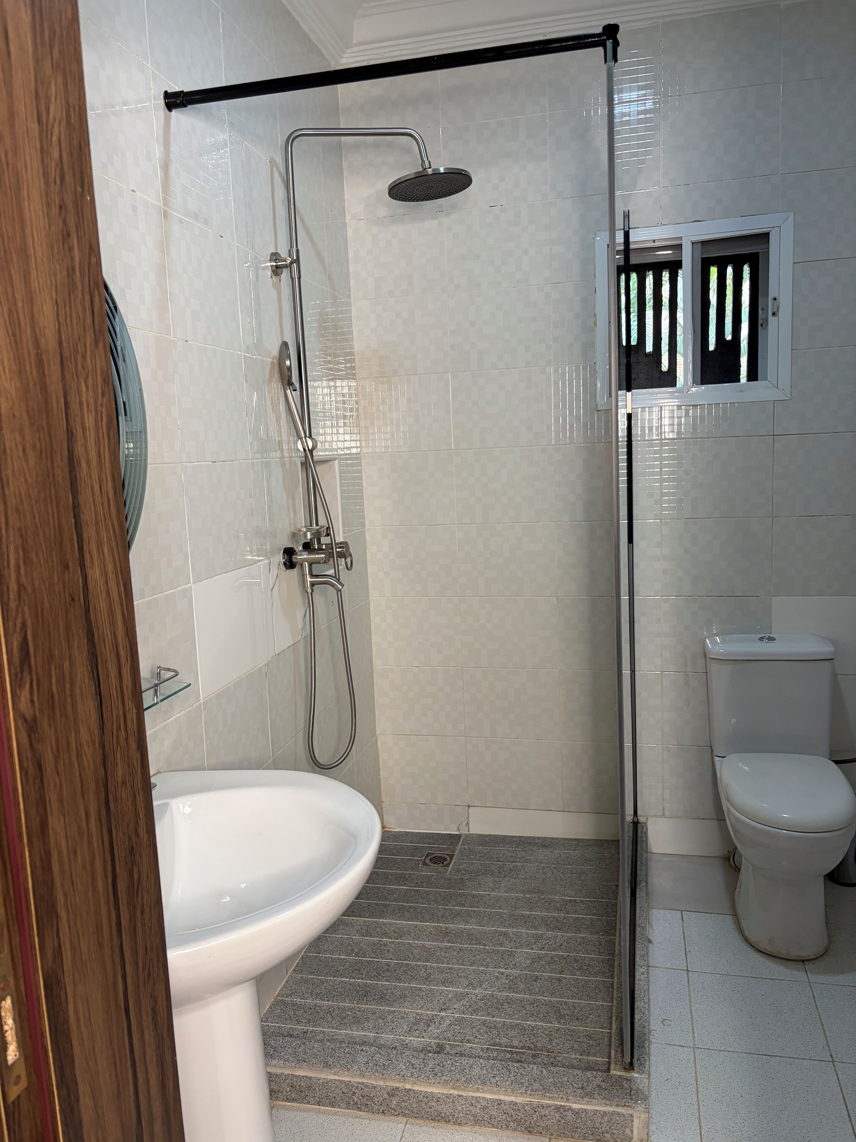 A bathroom with a shower, toilet, and sink.