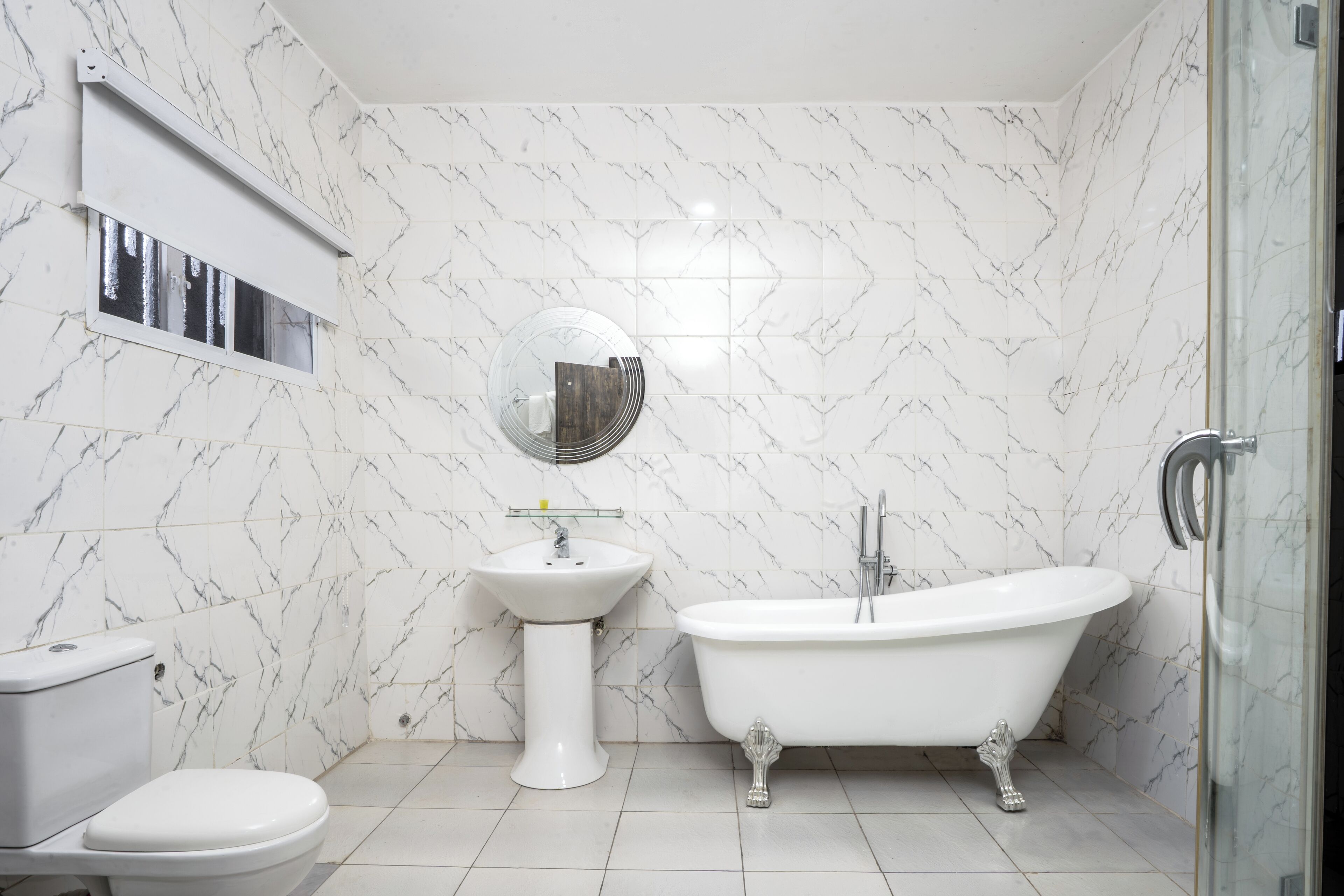 Een badkamer met toilet, wastafel en bad.
