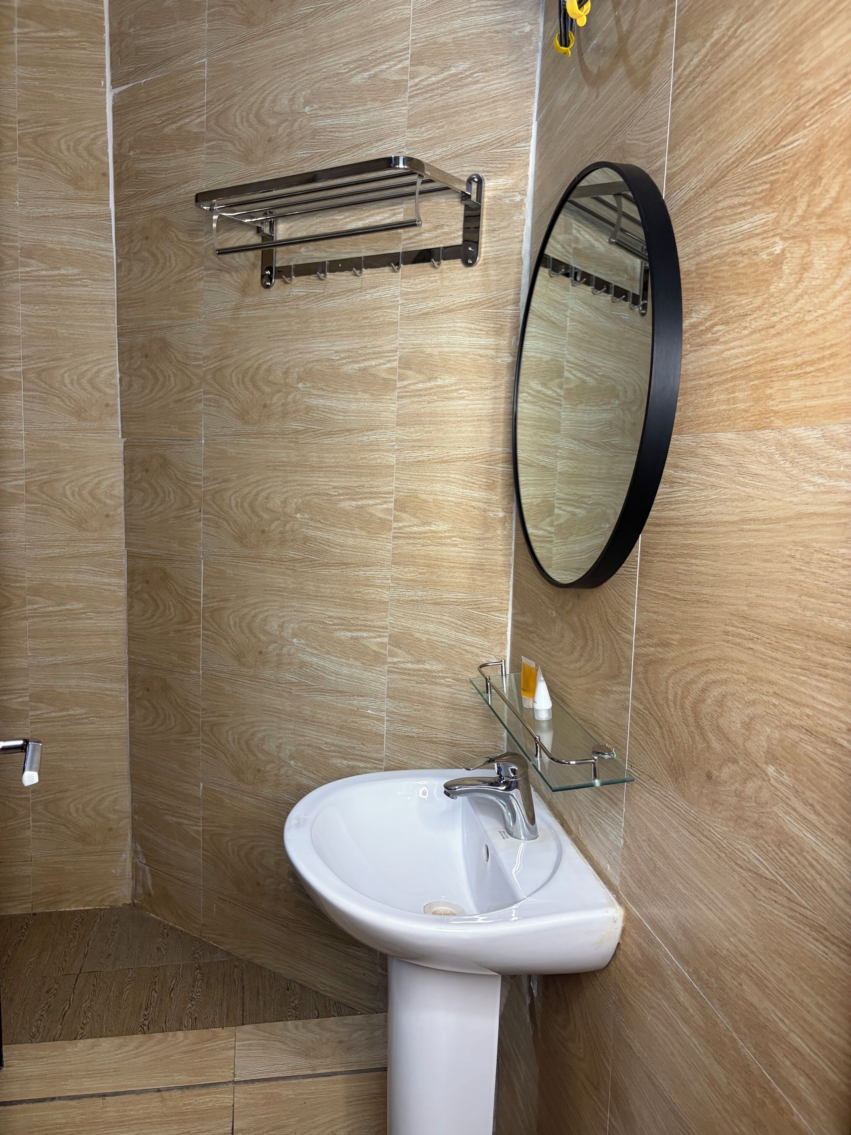A bathroom with a white sink, a mirror, and a towel rack.