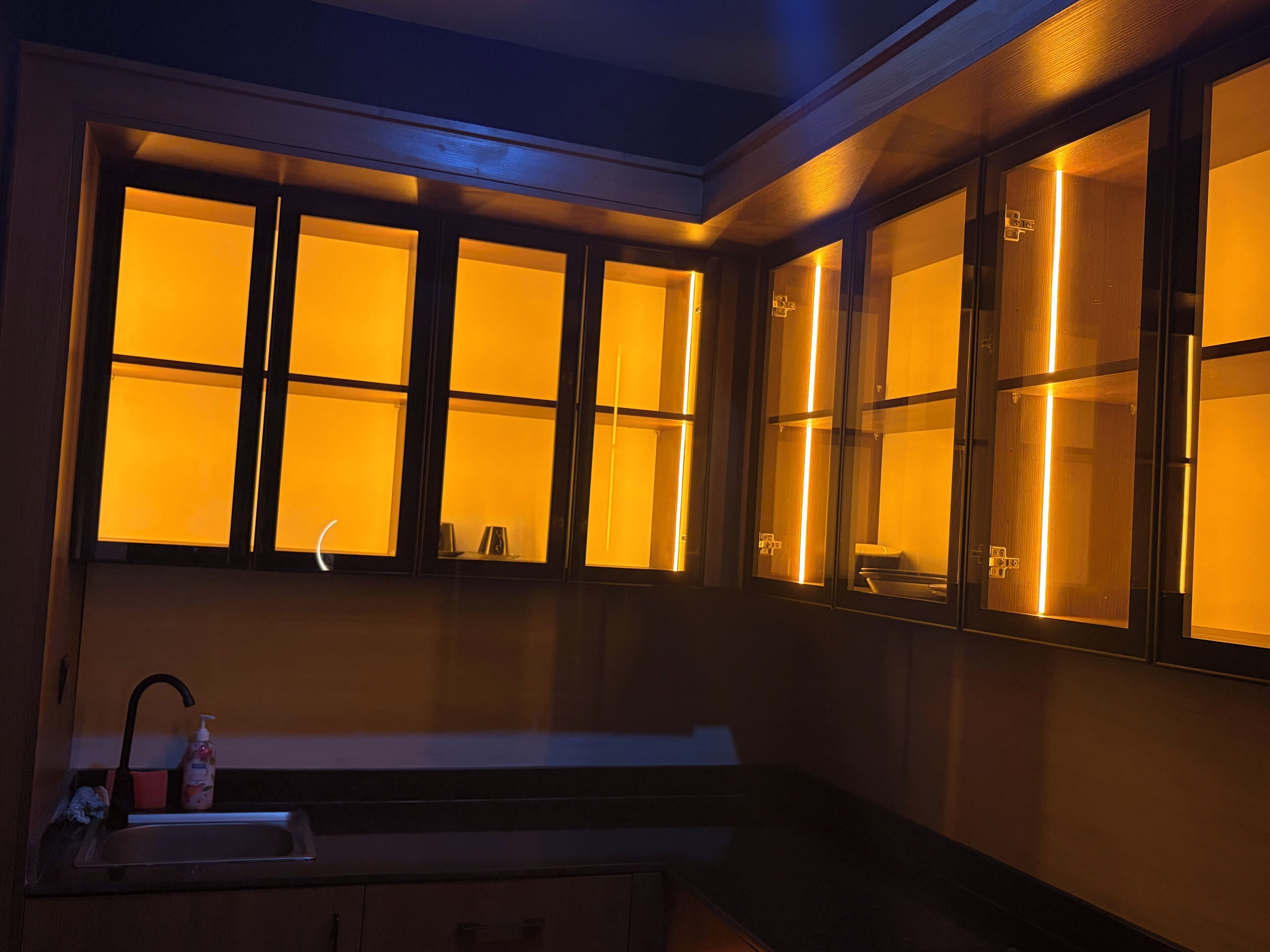 A kitchen with a sink, a window with a view, and a cabinet.
