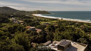 Une vue côtière avec une plage, des maisons et de la végétation.