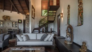 Un vaste espace de vie comprenant un canapé, une table à manger et un escalier menant à l’étage supérieur.