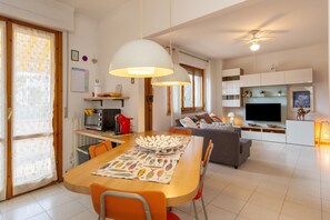 Um espaço moderno para viver com área de refeições, cozinha e sala de estar.
