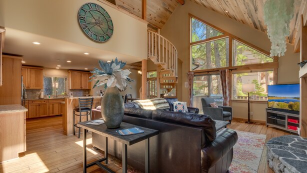 A spacious living area with a large clock, a fireplace, and a cozy seating arrangement. - The Westlands Lodge 1135ac 4 Bedroom Home (South Lake Tahoe)