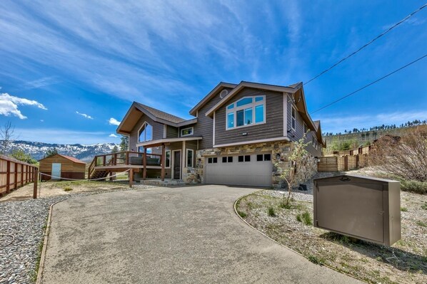 A two-story house with a garage, a covered porch, and a stone foundation. - 1008c Mountain View Retreat 5 Bedroom Home (South Lake Tahoe)