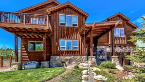 A wooden cabin with a stone foundation, a balcony, and a stone fireplace. - 1376md Angora View 4 Bedroom Home (South Lake Tahoe)