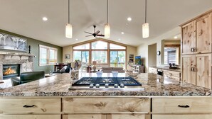 A spacious kitchen with granite countertops, a built-in stove, wooden cabinets, and pendant lighting. - 1376md Angora View 4 Bedroom Home (South Lake Tahoe)