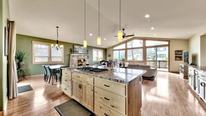 A spacious kitchen with a large island, wooden cabinets, and pendant lighting. - 1376md Angora View 4 Bedroom Home (South Lake Tahoe)