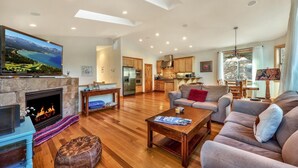 A spacious living room with a fireplace, a television, and a sofa.