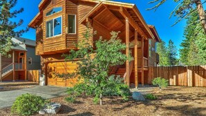 A two-story log cabin with a covered porch and a garage.