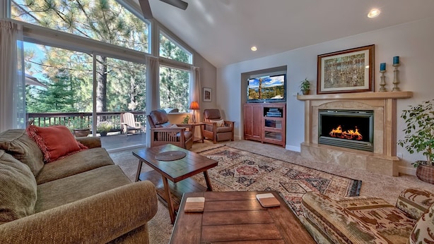 A spacious living room with a fireplace, large windows, and a cozy seating area. - 1272g Where Eagles Fly 3 Bedroom Home (South Lake Tahoe)