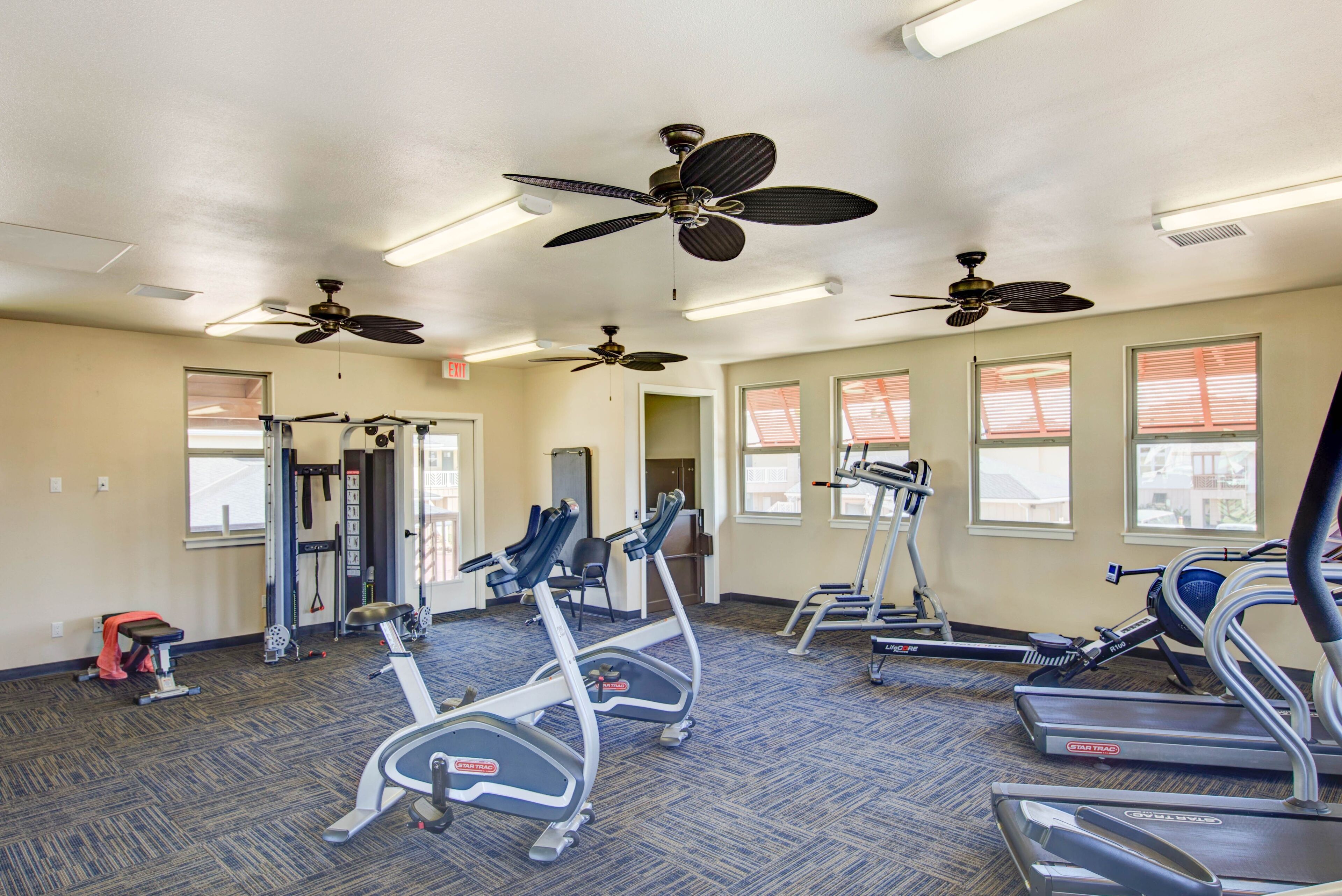 A gym with treadmills, elliptical machines, and weightlifting equipment.