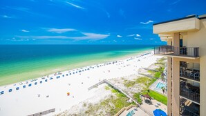 A beach view from a hotel balcony with a pool and lounge area. - Phoenix Ii 2151 3 Bedroom Condo (Orange Beach)