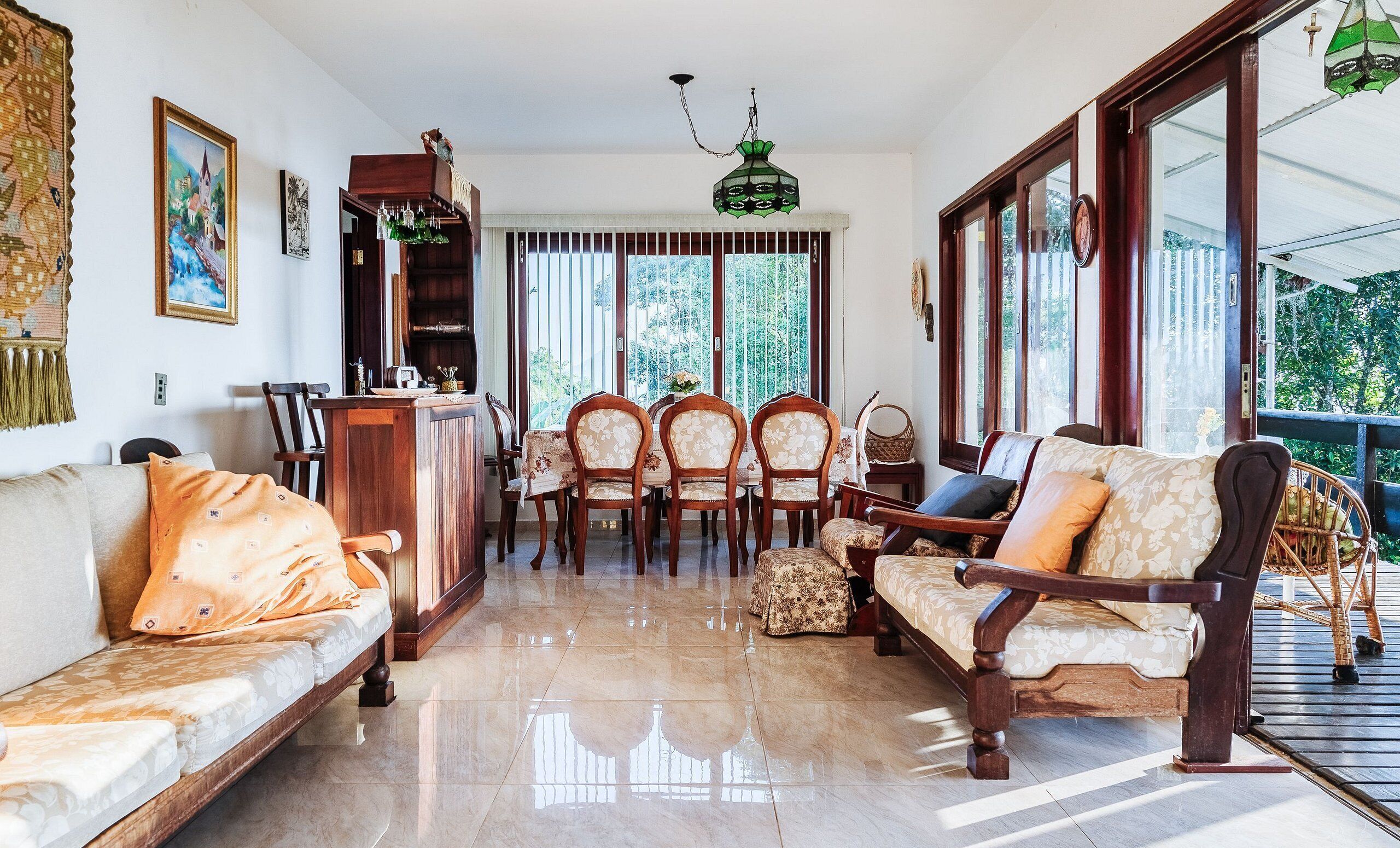 Un salón espacioso con sofá, sillones, una mesa de comedor y una zona de bar.